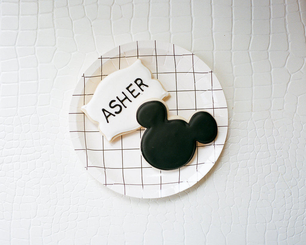 ASHER’S MODERN MICKEY 2ND BIRTHDAY PARTY - Life Lutzurious; Asher’s Modern Mickey Birthday party is LIVE. If you guys know me, party planning is ranked right up there with Gucci, ranch dressing, chips and salsa, college football, and wine. While I do have a strong disdain for commercially licensed characters, it only made sense to celebrate our Main Man’s 2nd birthday with his “girlfriend,” Minnie Mouse! Remember his black and white, modern 1st birthday party last year? You will definitely see some similarities. Here are MICKEY BIRTHDAY PARTY TIPS! modern Mickey Mouse birthday party // // custom Mickey Ear cookies // grid pattern party plates // kid's birthday party inspiration // 2nd birthday party ideas // Blogger Lindsey Lutz from Life Lutzurious details her son Asher's Modern Mickey 2nd Birthday Party